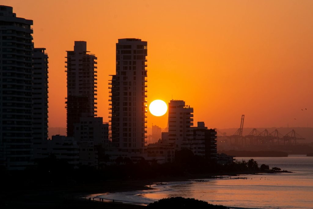 Dramatic sunset over Cartagena de Indias skyline, showcasing high-rise silhouettes by the sea, viajes a Cartagena