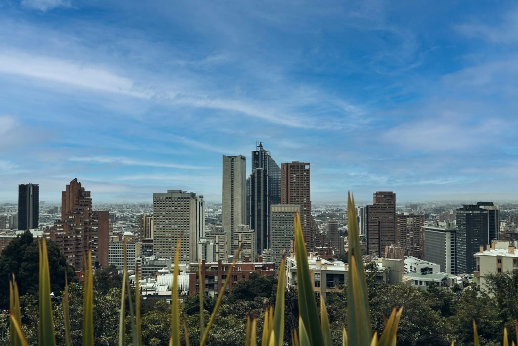 A picturesque view of Bogotá's skyline featuring modern skyscrapers against a bright blue sky, Planes en Bogotá