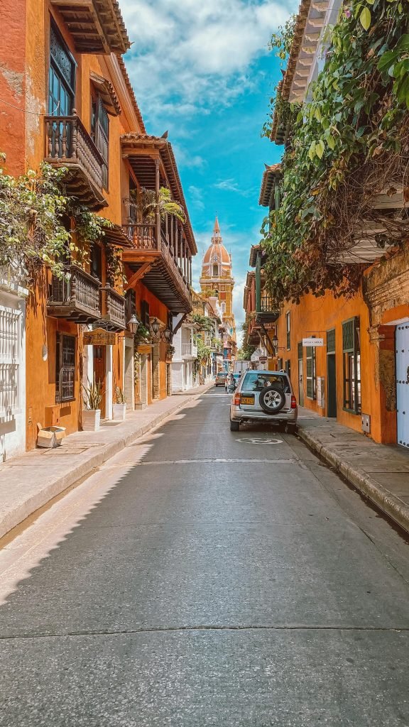 Charming street in Cartagena with vibrant buildings and cathedral in view, ideal for travel inspiration, Qué hacer en Cartagena