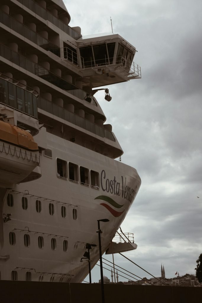 Close-up of the Costa Venezia cruise ship docked at port under cloudy skies, cruceros