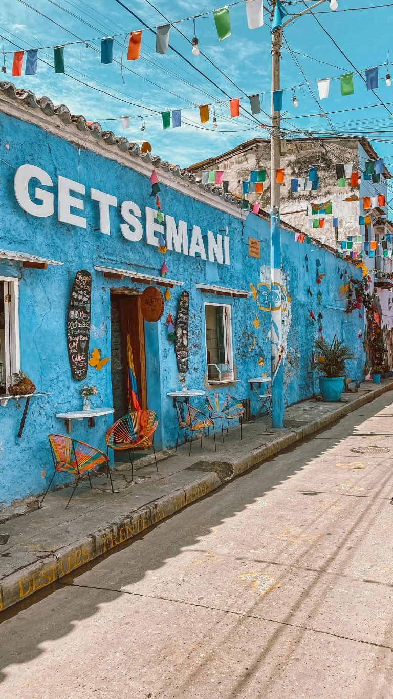 Vibrant blue facade in Getsemaní, Cartagena with colorful decorations and flags, Qué hacer en Cartagena