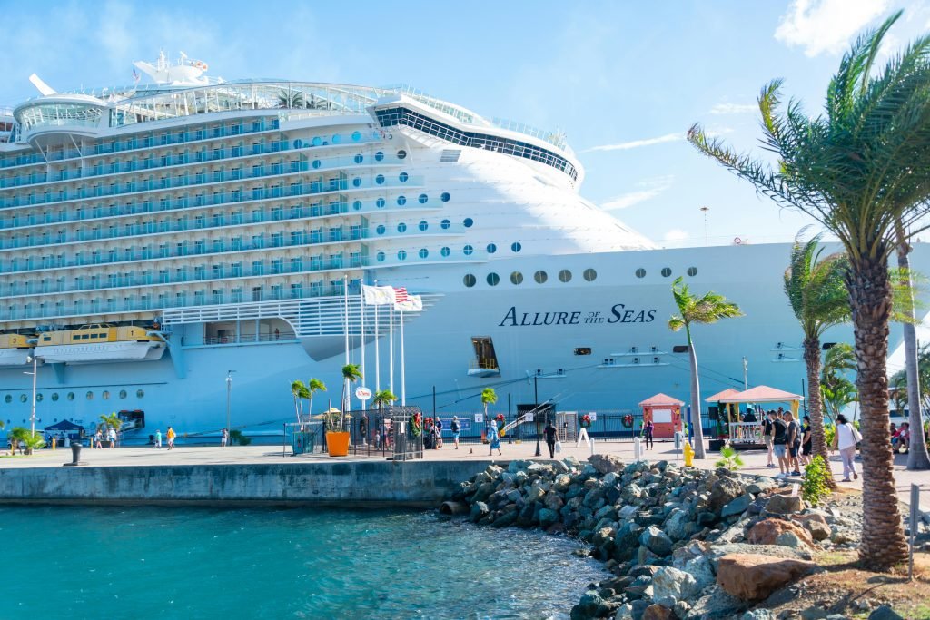Discover the majestic Allure of the Seas docked in a vibrant tropical port, cruceros