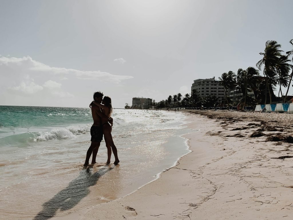 A couple shares a romantic embrace on a picturesque San Andrés beach. Perfect serene getaway., Lugares turísticos de Colombia