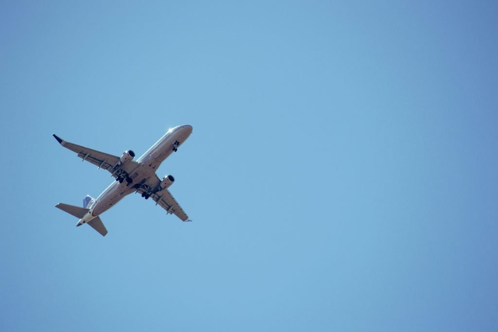 A commercial airplane captured mid-flight against a clear blue sky., pasajes