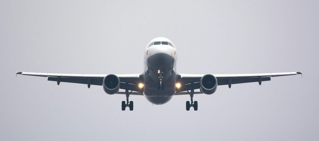 A commercial airliner captured head-on, preparing to land against a cloudy sky., pasajes
