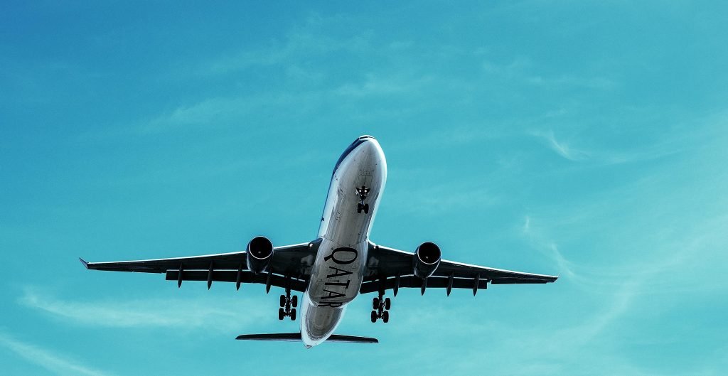 A Qatar Airways commercial airplane takes off into a clear blue sky, showcasing transportation at its finest., pasajes