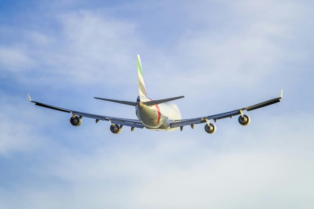 A commercial passenger airplane flying high in the sky viewed from behind., pasajes