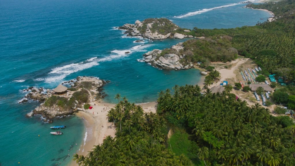 Stunning aerial drone shot of Tayrona National Park's coastline in Colombia, showcasing turquoise waters and lush greenery., Tayrona