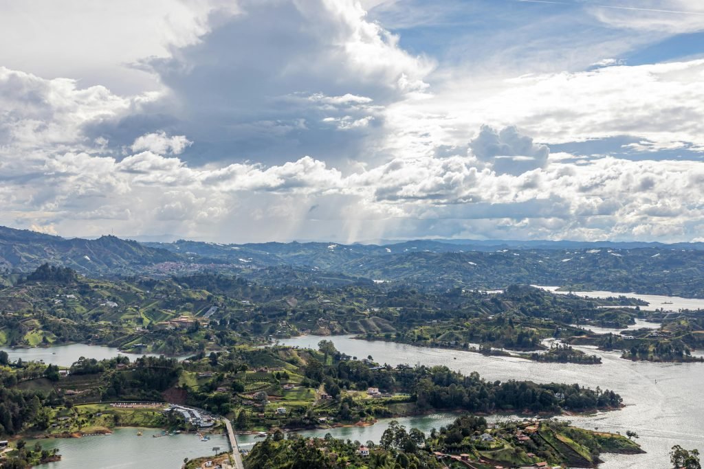 A breathtaking aerial view of the lakes and rolling hills in Guatapé, Antioquia, Colombia, under a dramatic sky., ¿es seguro viajar a Colombia?