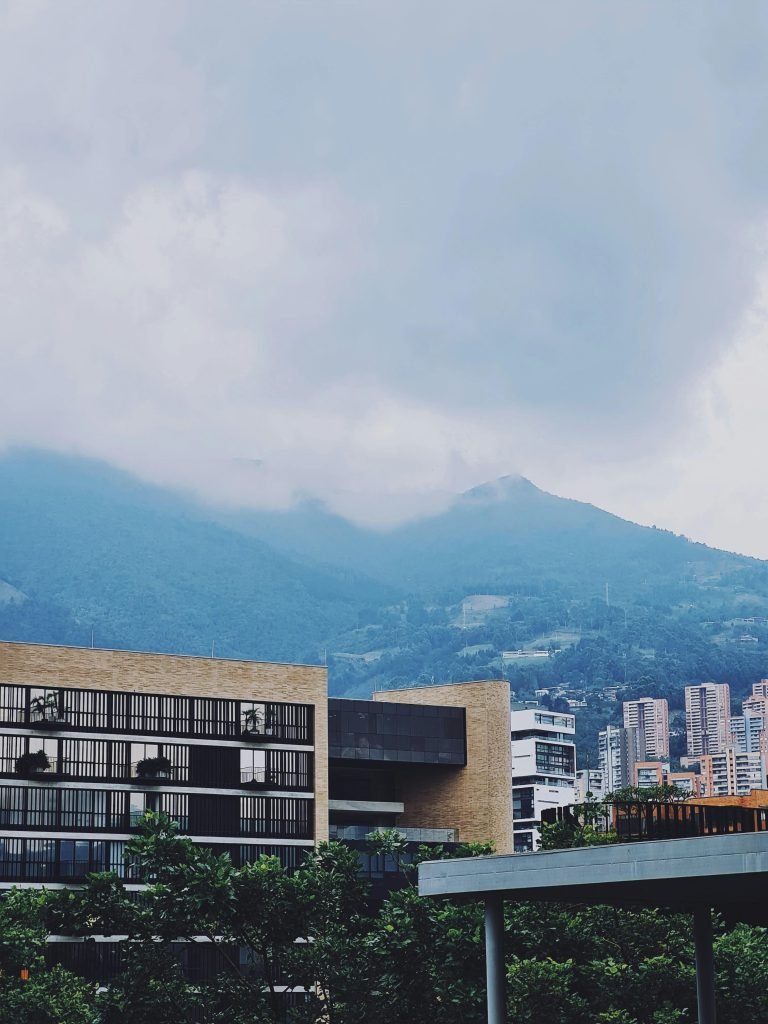 A picturesque view of modern buildings in Medellín with mountains in the background., ¿es seguro viajar a Colombia?