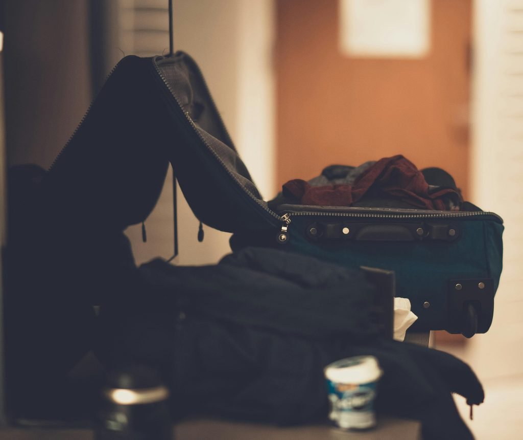 A warm-toned indoor image of an open suitcase with clothes, conveying travel readiness., equipaje