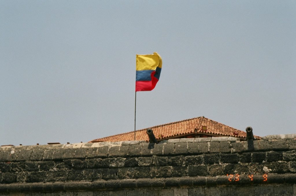 Colorful Colombian flag waving at a historic fort in sunny Cartagena, Colombia., paquetes a Cartagena todo incluido