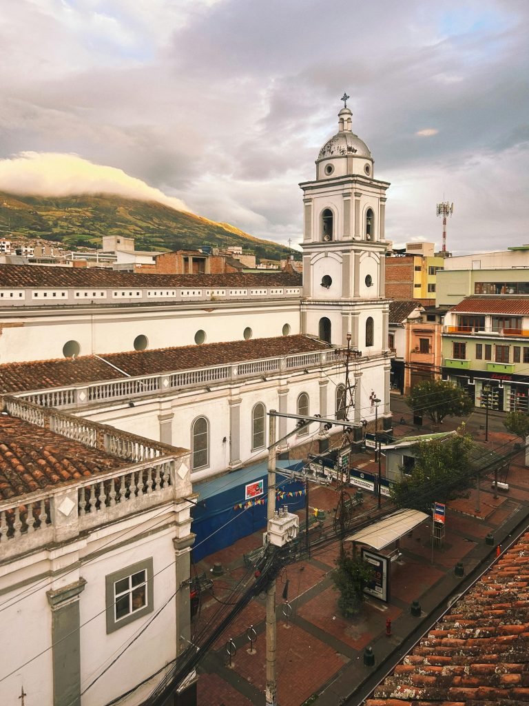 A picturesque view of a historic church in Pasto, Colombia, under a vibrant sunset., requisitos para viajar a Colombia