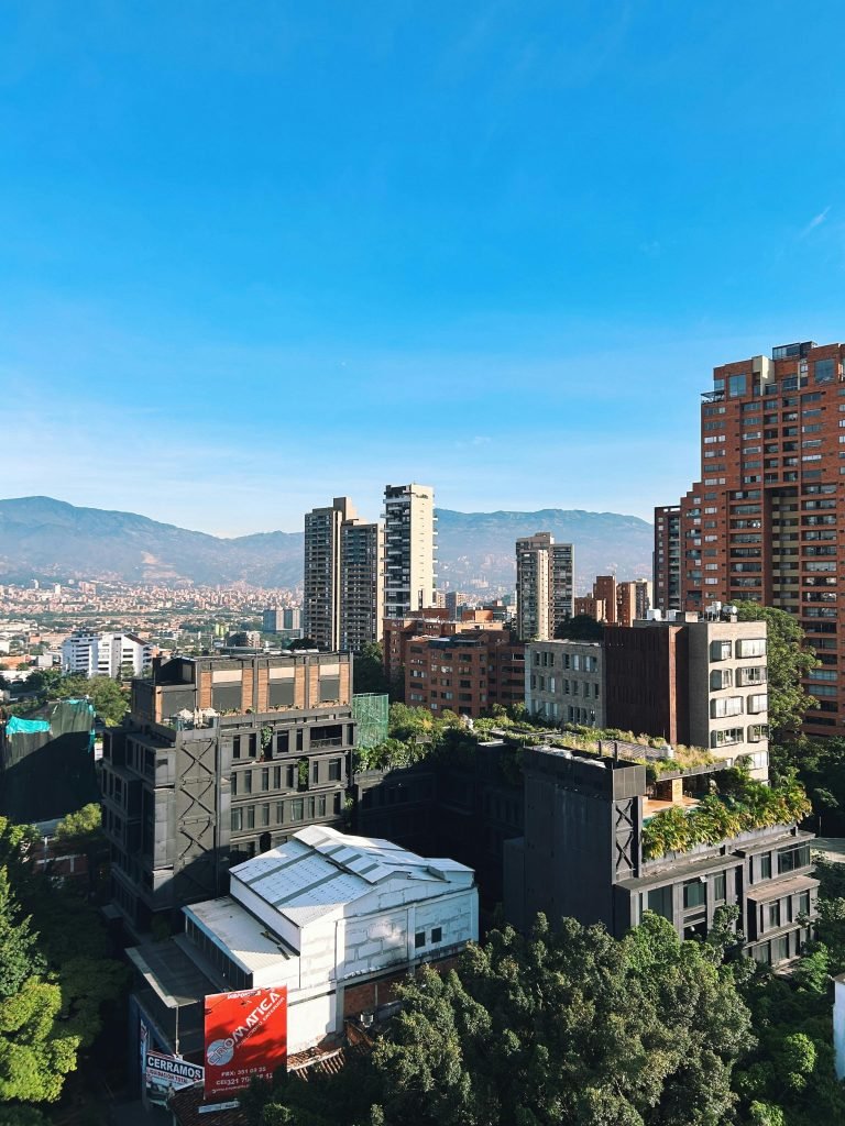 Bright day cityscape of Medellín, Colombia featuring modern architecture and green spaces., requisitos para viajar a Colombia
