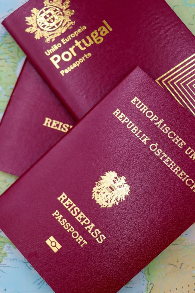 Close-up of Portugal and Austrian passports on a map, symbolizing travel and European mobility., visados