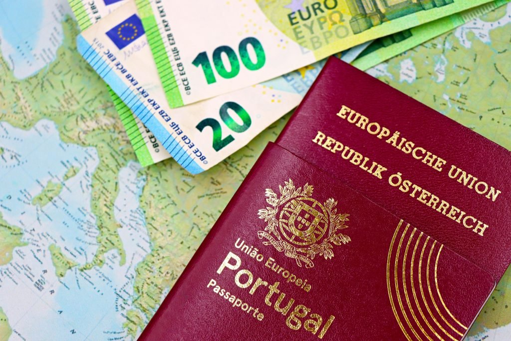 Portugal and Austria passports displayed with Euro currency notes on European map background., visados