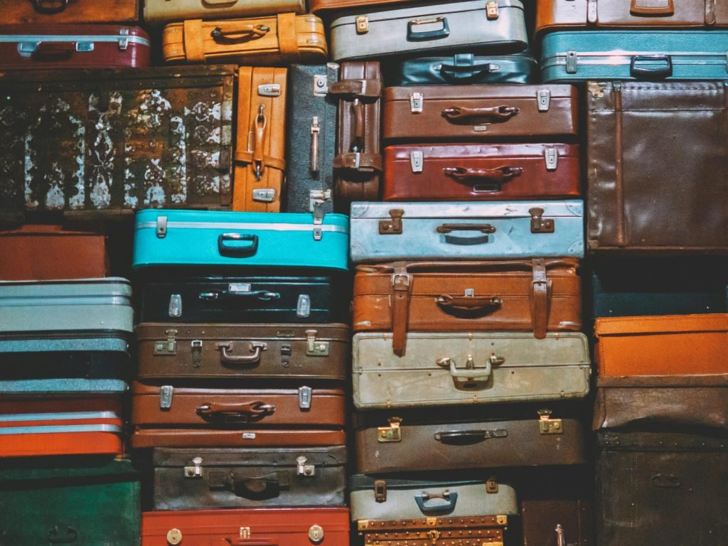 A colorful assortment of vintage suitcases stacked together, creating an artistic display., equipaje