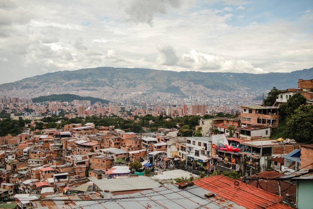 Stunning cityscape of Medellín with vibrant rooftops and distant mountains under a cloudy sky., ¿es seguro viajar a Colombia?