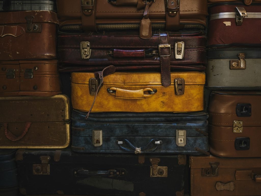 Vintage suitcases stacked in a rustic setting, showcasing classic travel charm., equipaje