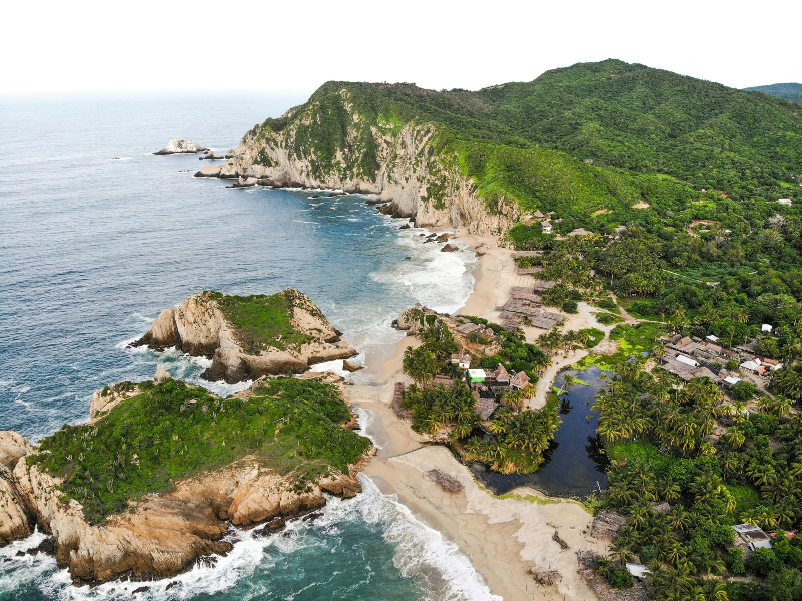 Stunning aerial view of Mexico's coastline with lush greens and rocky cliffs., Tayrona