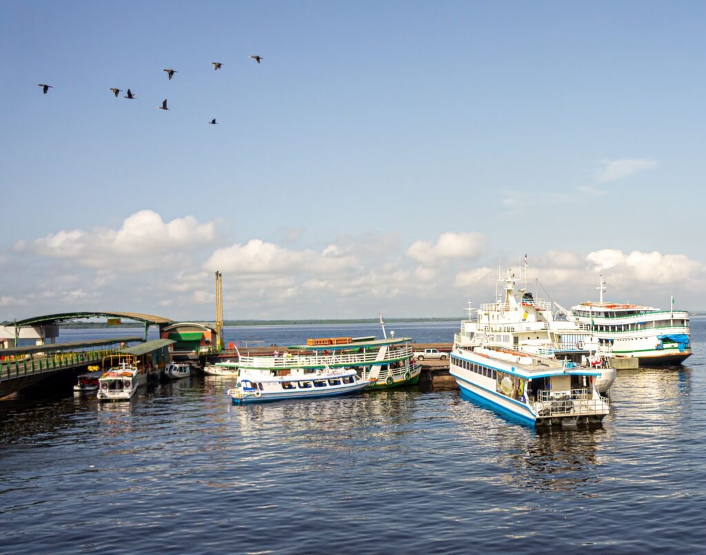 Scenic view of boats docked at a busy harbor in Manaus, Brazil with clear blue skies. Amazonas