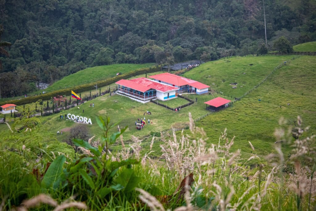Scenic aerial view of Cocora Valley, Colombia with lush greenery and iconic buildings.