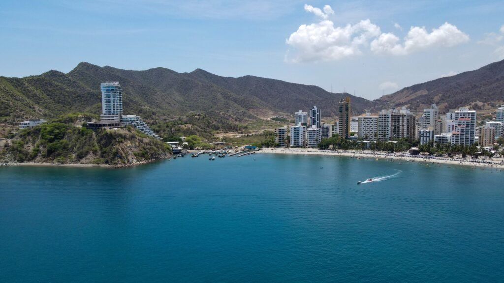 A vibrant coastal city with mountains, beach, and clear blue sea under a sunny sky. Santa Marta