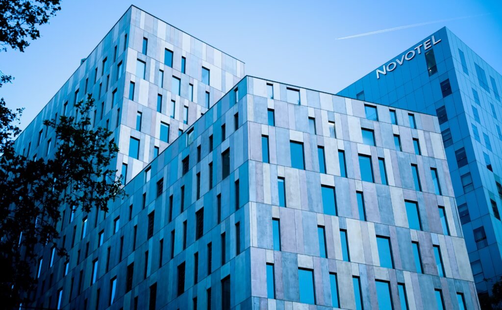 Blue-toned modern architecture of Novotel in Barcelona under a clear sky. hoteles
