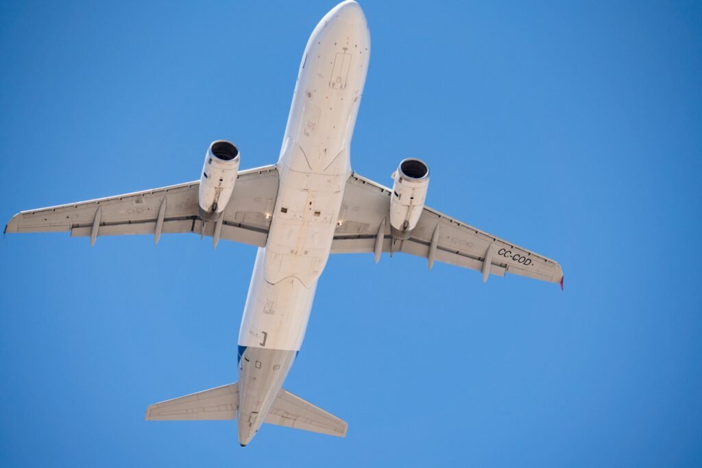 A commercial airplane flying overhead with a clear blue sky in Santiago, Chile. vuelos