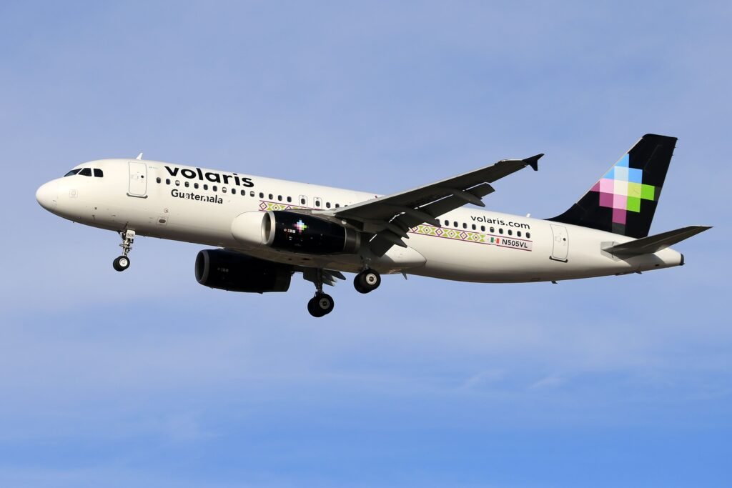 Volaris airplane in flight against clear blue sky, showcasing modern aviation. vuelos