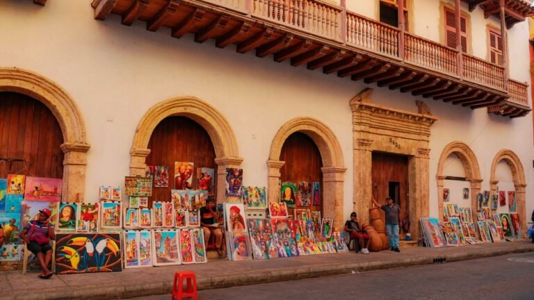 Colorful paintings on a charming Cartagena street attracting tourists with local culture.