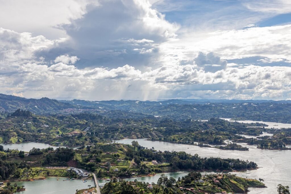 A breathtaking aerial view of the lakes and rolling hills in Guatapé, Antioquia, Colombia, under a dramatic sky., Vacaciones en Colombia