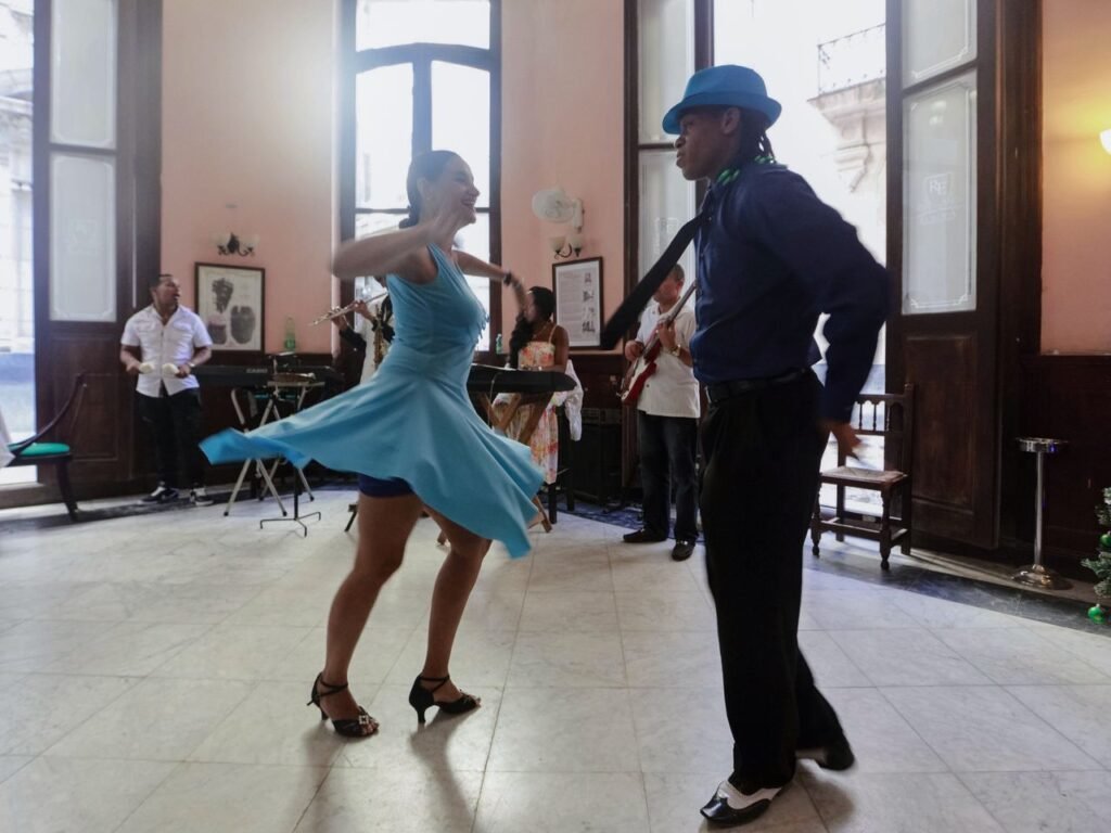 A lively couple dancing indoors with a live band in an elegant setting, exuding vibrancy and joy., Cali