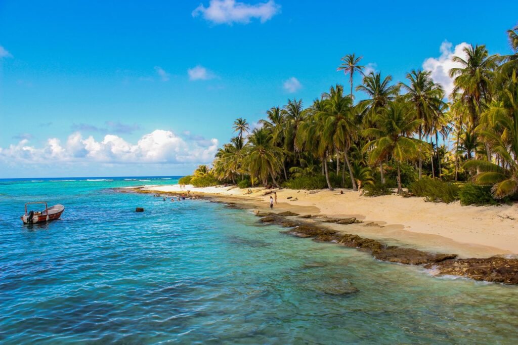 Scenic view of a tropical beach with palm trees and clear blue waters in San Andrés, Colombia. Viajes en pareja Colombia