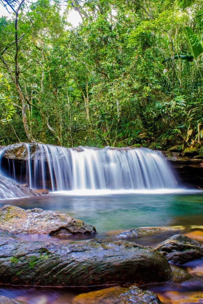 A serene waterfall in San José Del Guaviare, Colombia, surrounded by lush greenery.