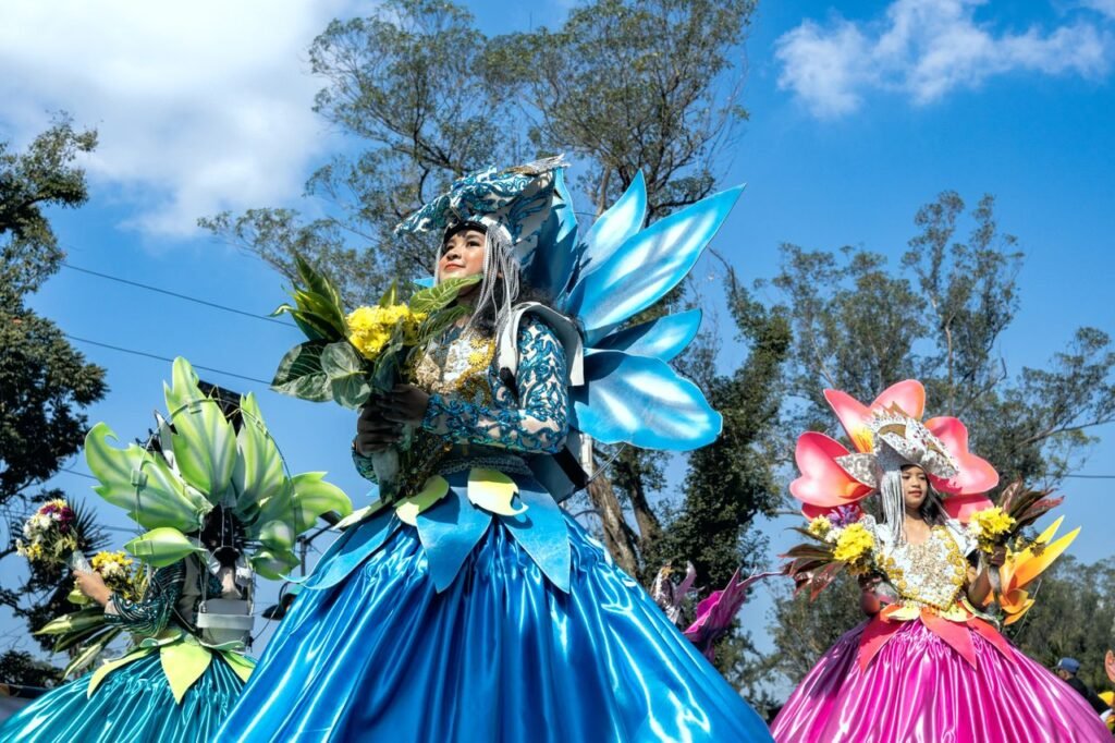 Women in vibrant floral costumes at the Baguio Flower Festival parade. Feria de las flores