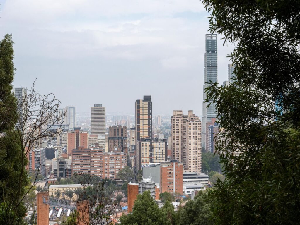 A scenic view of Bogotá's skyline surrounded by greenery, showcasing urban architecture and nature. viajes de lujo