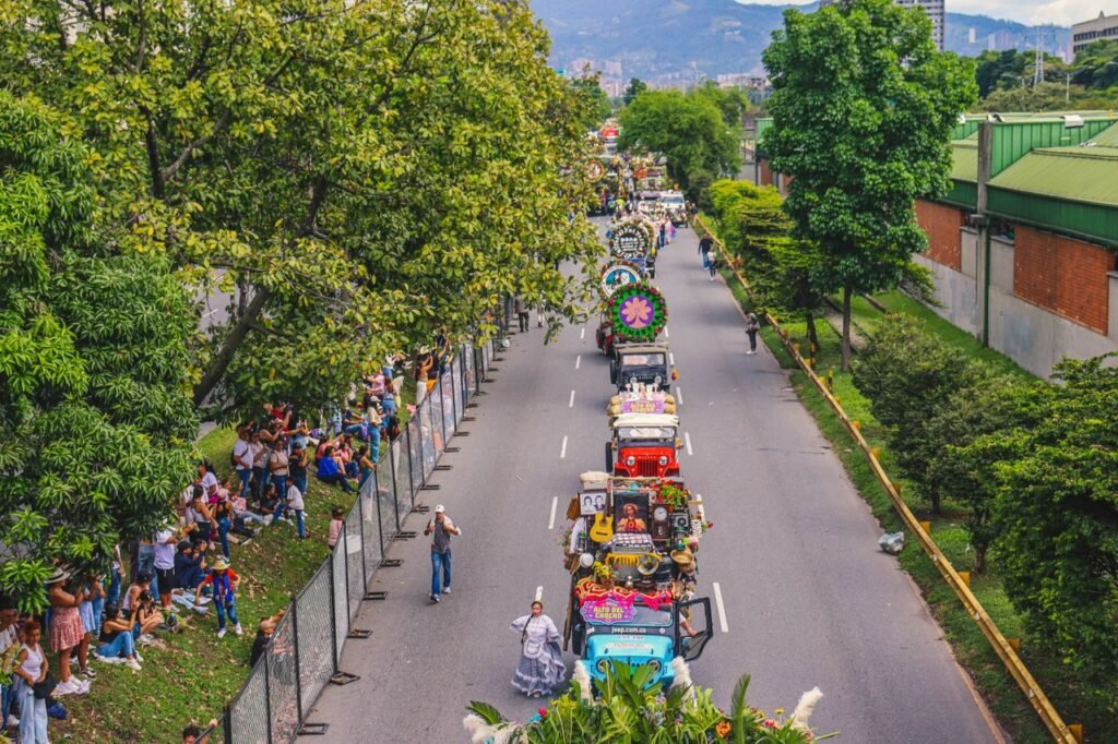 Vibrant parade scene during Medellín's Feria de Flores, showcasing decorated jeeps surrounded by lush greenery. Feria de las flores