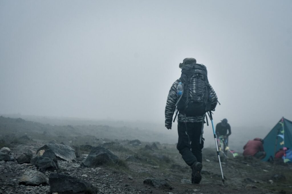 A hiker with gear treks through a foggy mountain landscape in Jawa Barat, Indonesia. Trekking en Colombia