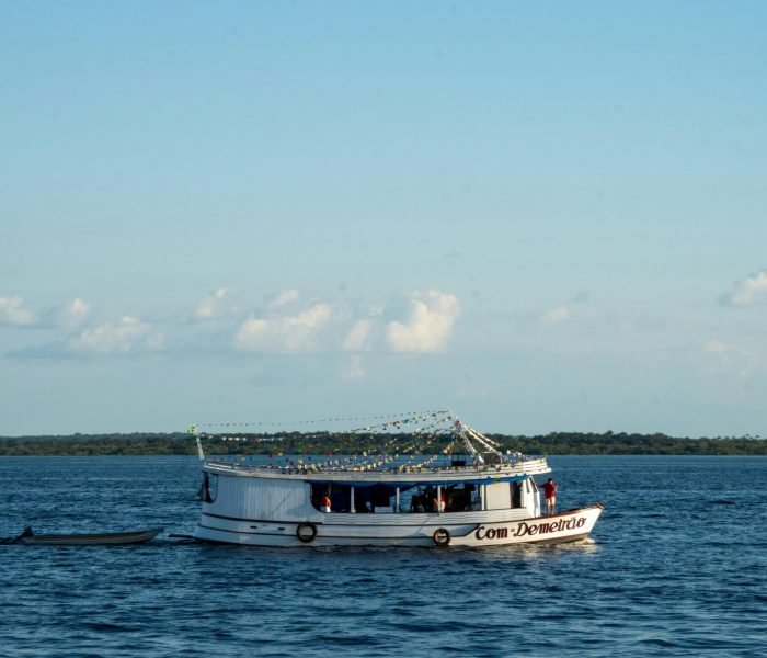 A boat sailing on the Rio Negro under a clear sky in Manaus, Amazonas.